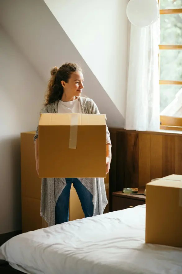 A woman holding a packed cardboard box