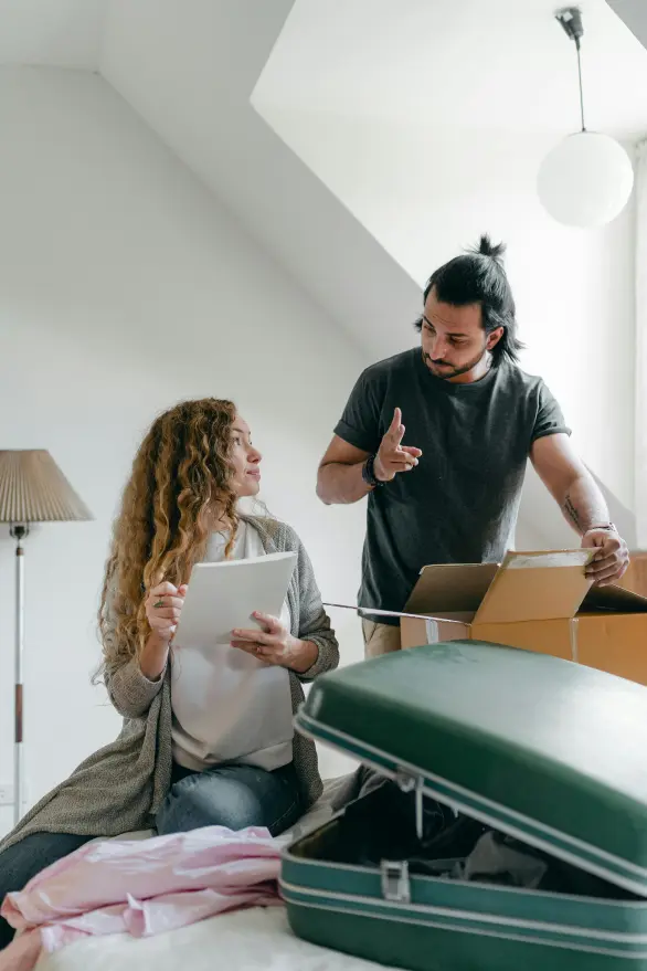A man and a woman discussing clutter and packing boxes