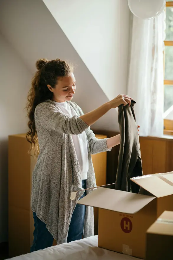 A woman thinking about a piece of clothing to get rid of
