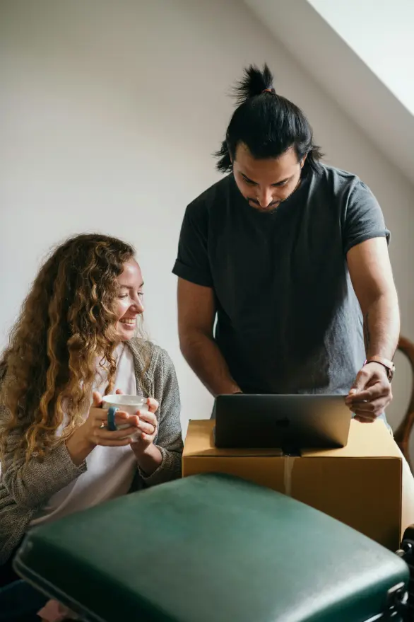A man & woman review their declutter plan as they pack