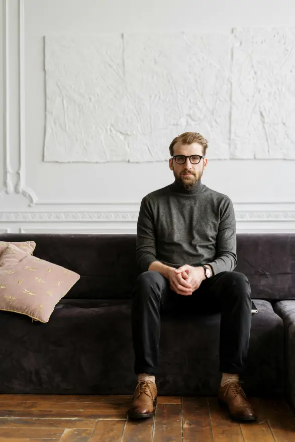 A man on a couch ready to help others learn about essentialism